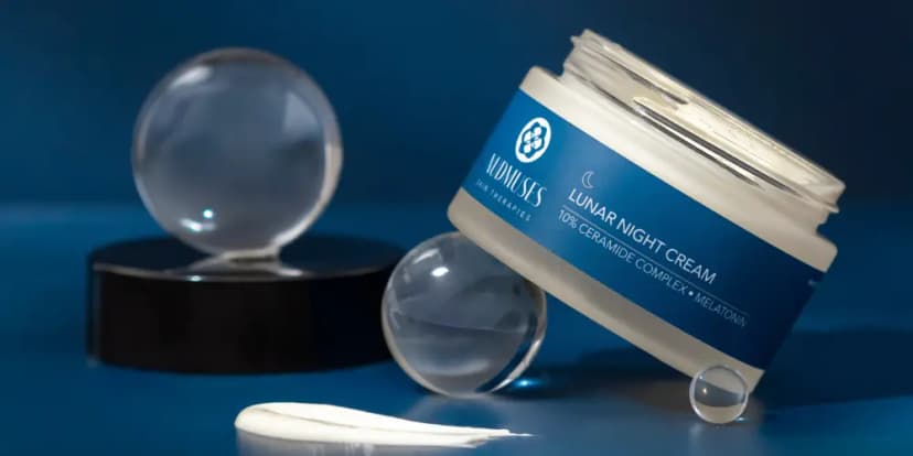 Nudmuses Lunar Night Cream with ceramide complex and melatonin, presented with glass transparent blue spheres.